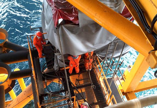 Picture of men working on a oil rig close to sea level
